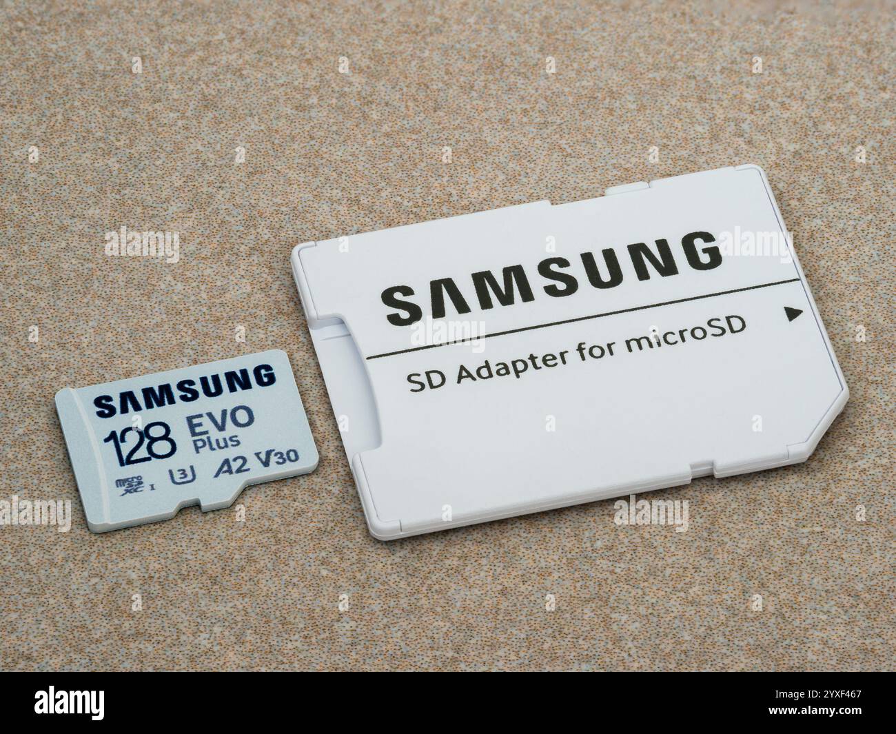 Zaporizhzhia, Ukraine - 19 août 2024 : Samsung microSDXC Class 10 UHS-I U3 V30 A2 EVO plus carte mémoire 128 Go et adaptateur SD sur surface céramique Banque D'Images