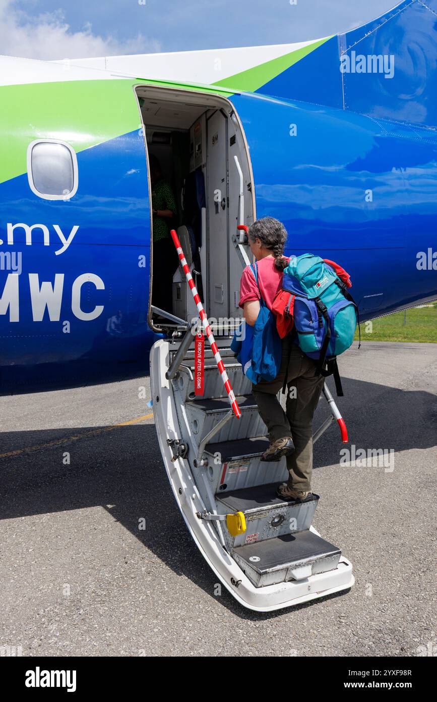 Passager avec sac à dos bagage à main embarquant dans l'avion Mass Wings, Mulu, Sarawak, Malaisie, Bornéo Banque D'Images