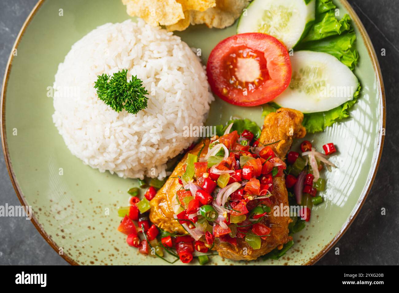 Nasi Ayam Geprek est un poulet frit croustillant de cuisine indonésienne avec du bawang sambal chaud et épicé. Servi avec du riz Banque D'Images