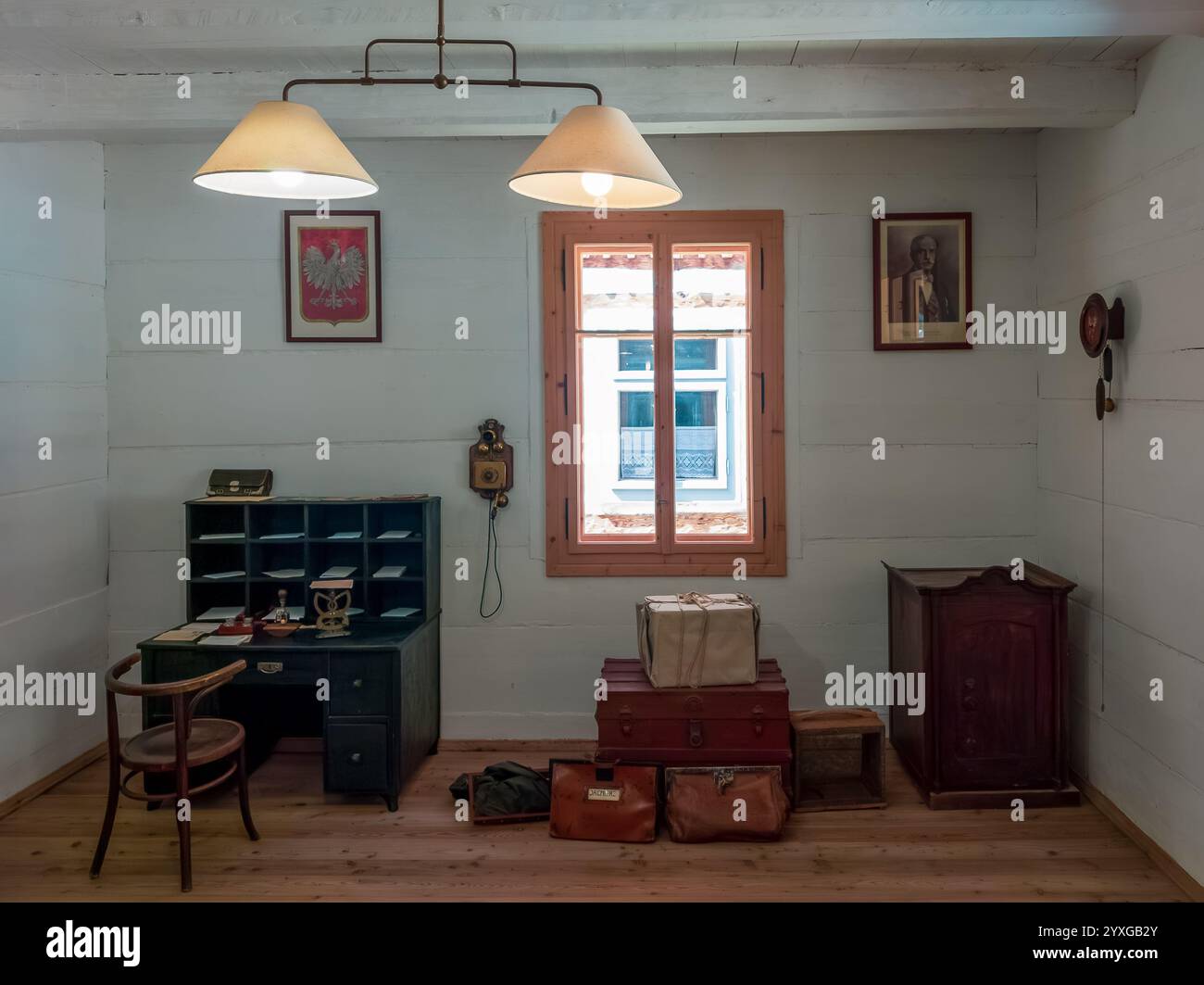 Sanok, Pologne - 4 mai 2024. Intérieur de bureau de poste vintage avec bureau, bagages et emblème polonais au Musée d'architecture folklorique de Sanok. Banque D'Images