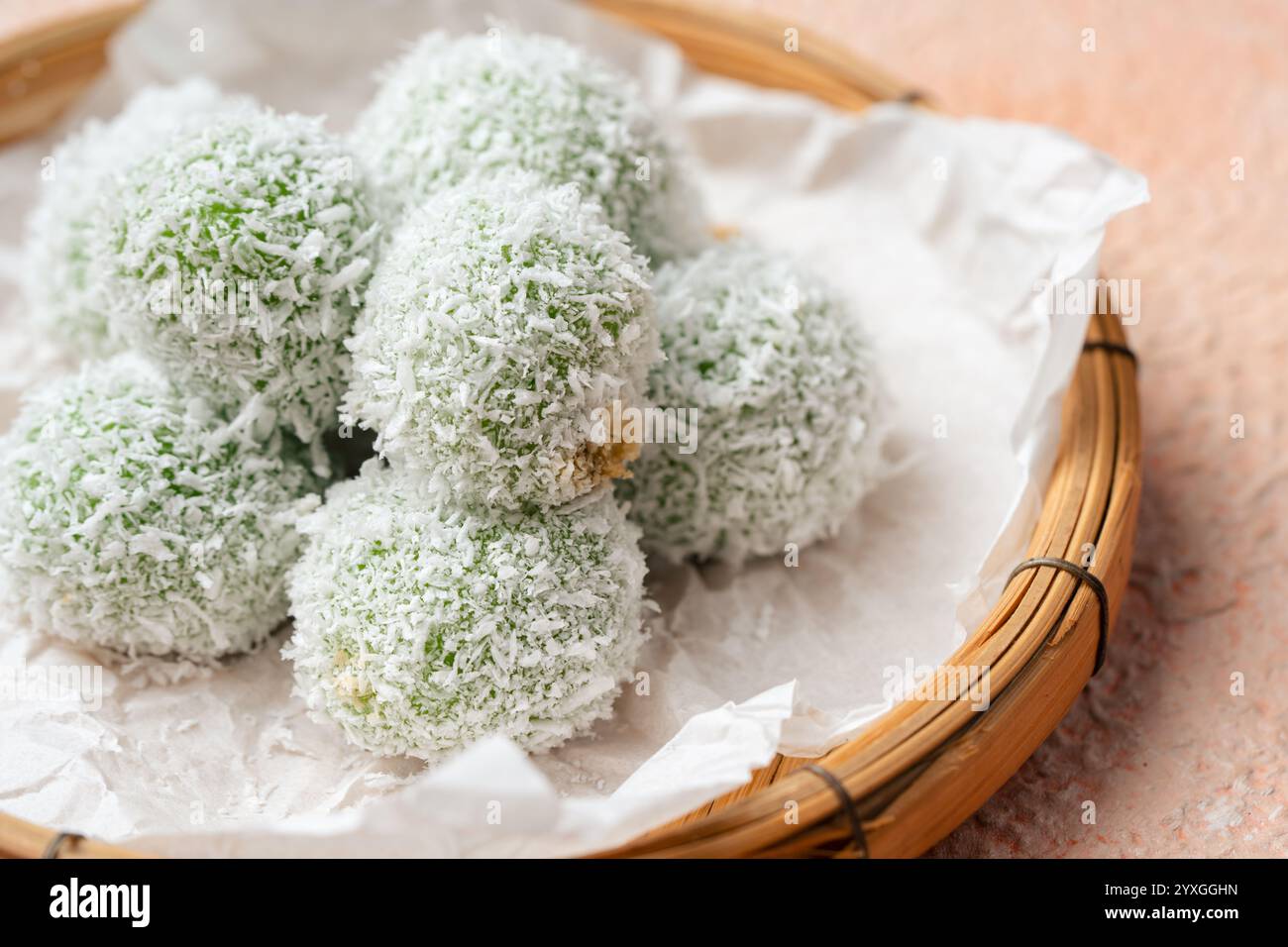 kelepon ou klepon ou onde-onde à base de farine de riz gluante et fourrée de sucre bruni recouvert de noix de coco râpée. Banque D'Images