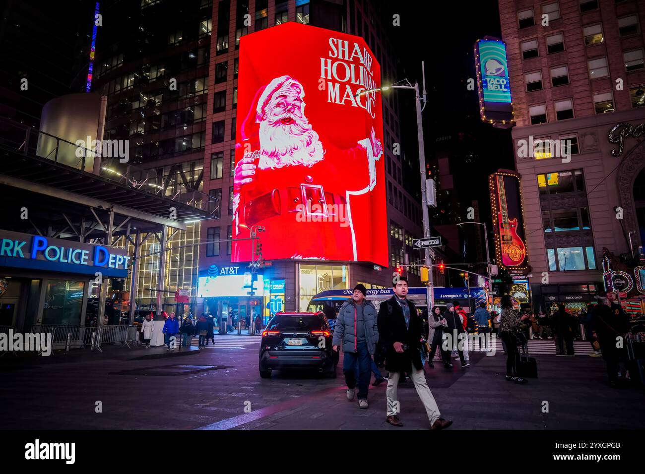 Les visiteurs de Times Square à New York le mercredi 4 décembre 2024 se promènent sous plusieurs panneaux d'affichage numériques sur le thème de Noël faisant la publicité de Coca-Cola. (© Richard B. Levine) Banque D'Images