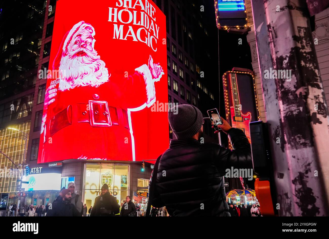 Les visiteurs de Times Square à New York le mercredi 4 décembre 2024 se promènent sous plusieurs panneaux d'affichage numériques sur le thème de Noël faisant la publicité de Coca-Cola. (© Richard B. Levine) Banque D'Images