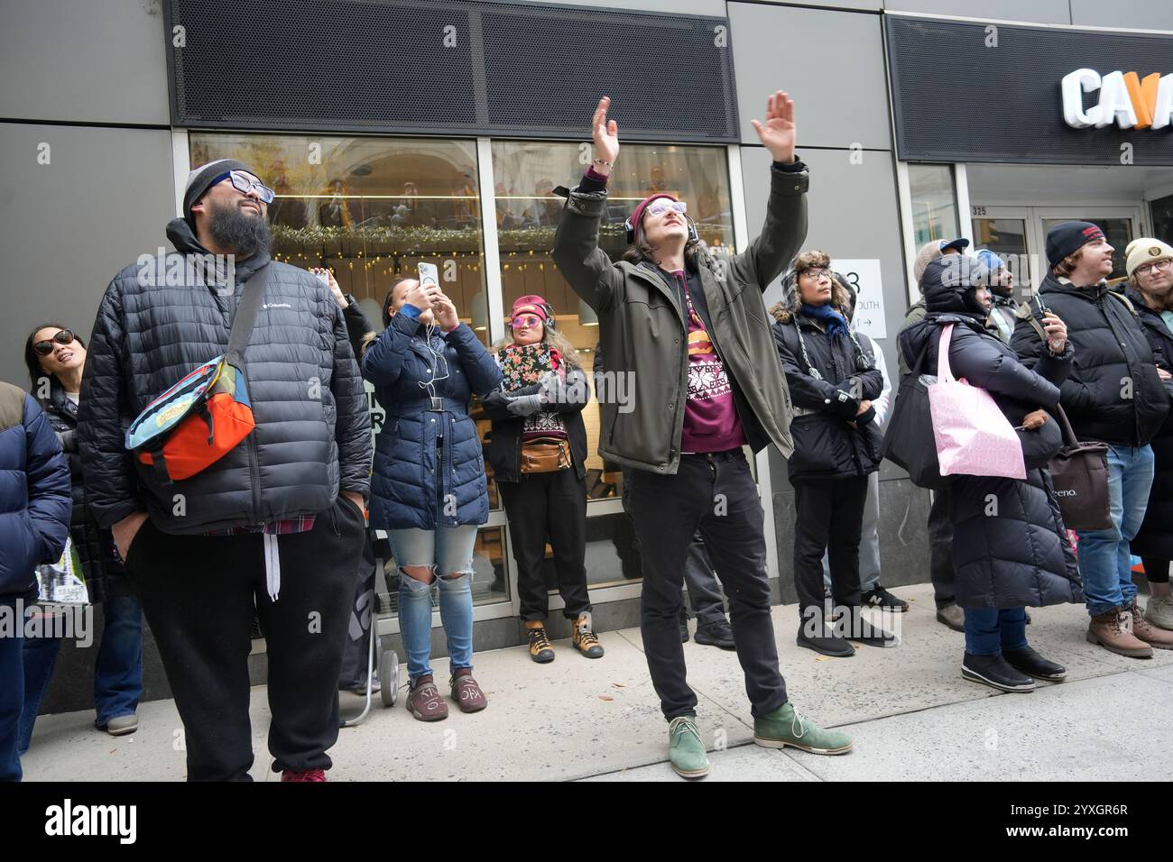 Le chef de chœur dirige avec des fans de McDonald’s au bus McDonald’s « Caroloke » garé dans le Gramercy Park à New York le dimanche 15 décembre 2024. Le bus, promouvant le retour du sandwich McRib, était livré avec le McRib Caroloke Choir et un affichage numérique où les participants pouvaient chanter des chansons sur le thème de Noël, style karaoké, avec des paroles humoristiques qui ont été « McRibified ». (© Richard B. Levine) Banque D'Images