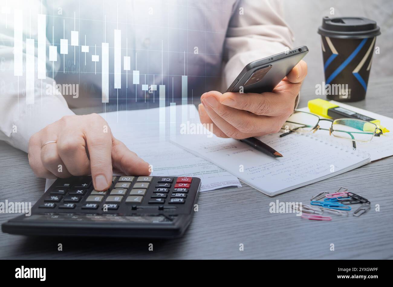 Calculer les dépenses et analyser les données financières dans un espace de travail professionnel avec notes et papeterie à proximité pour référence. Banque D'Images