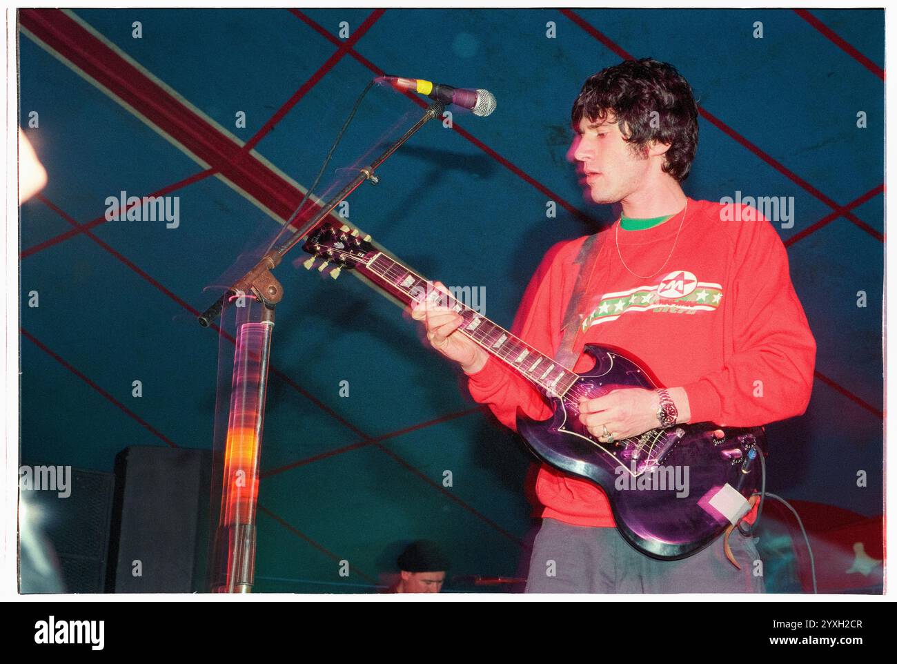 SUPER FURRY ANIMALS, ESSENTIAL FESTIVAL, CONCERT, BRIGHTON, 1996 : Gruff Rhys of the Super Furry Animals Playing LVE at the Essential Festival 1996 at Stanmer Park à Brighton, Angleterre, Royaume-Uni le 25 mai 1996. Photo : Rob Watkins. INFO : Super Furry Animals est un groupe de rock gallois formé en 1993, connu pour son style éclectique mêlant rock, psychédélie et musique électronique. Acclamés pour des albums comme « Rings Around the World » et « Phantom Power », ils sont un élément clé de la scène alternative des années 1990. Banque D'Images