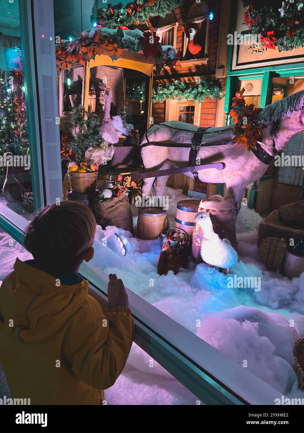 Les enfants regardent l'historique vitrine de Noël de Woodward avec cheval animatronique, tonneaux et décorations de vacances avec éclairage coloré et Ar Banque D'Images