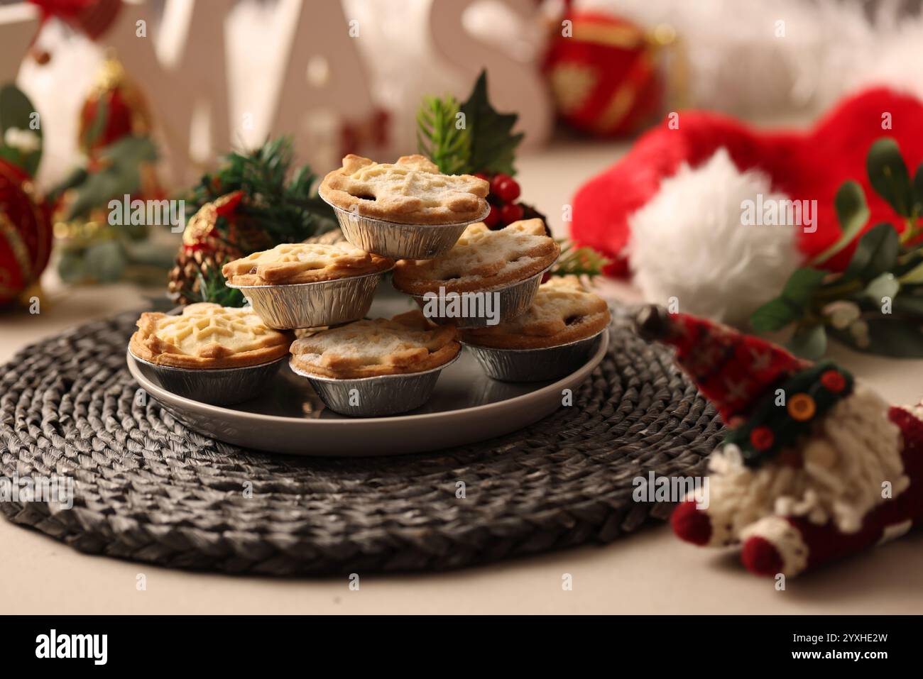 Une assiette de tartes hachées et le mot XMAS en caractères blocs Un chapeau de père noël est posé sur le côté. Banque D'Images
