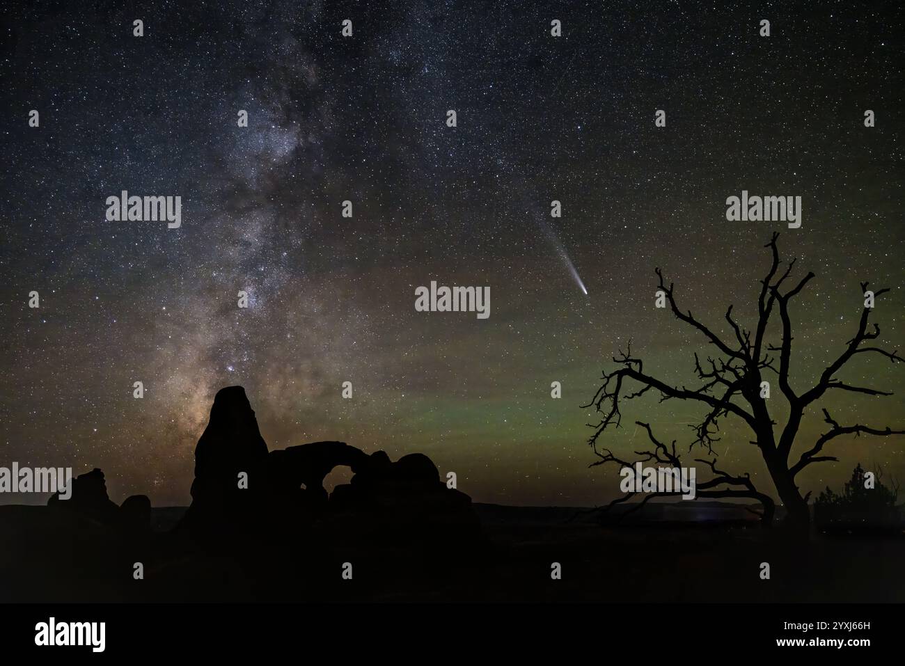 Turret Arch et un arbre mort sont silhouettés contre le C/2023 A3 (Tsuchinshan–ATLAS) la voie lactée et un peu d'air vert brille dans le parc national des Arches ou Banque D'Images