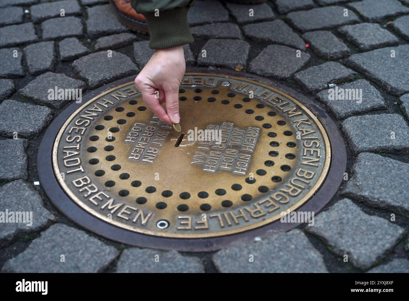 Brême, Allemagne, 4 décembre 2024 : trou de Brême, boîte de dons souterraine dans le trottoir de la place du marché. Lorsqu'une pièce de monnaie est insérée, l'animal sou Banque D'Images