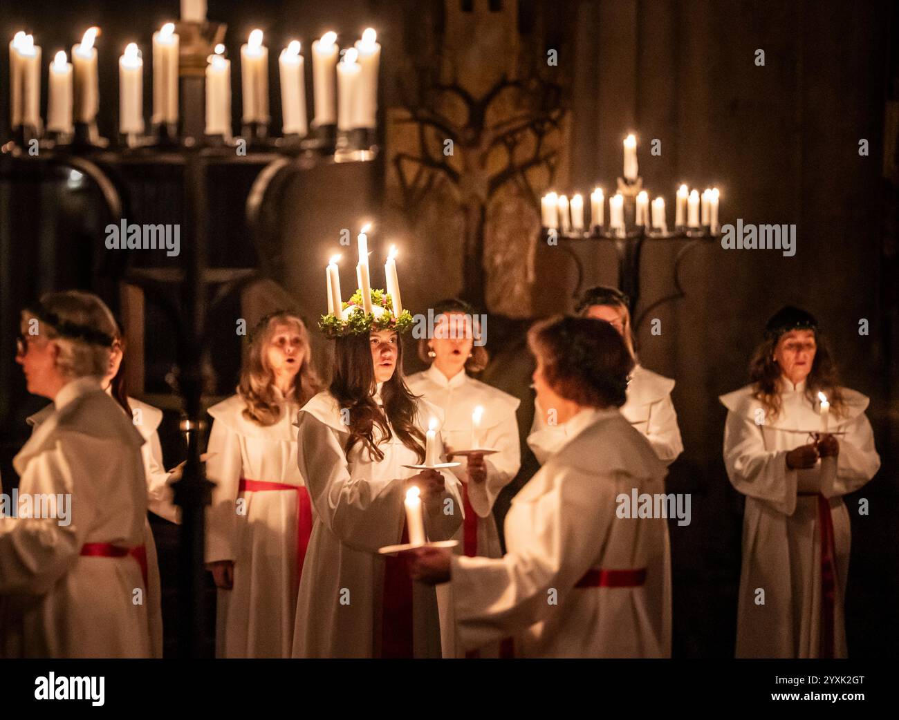 Alida Freding porte une couronne de bougies symbolisant Sainte Lucy alors qu'elle dirige la célébration de Sankta Lucia : Festival of Light at York Minster, basée sur la bravoure et le martyre d'une jeune fille sicilienne Sainte Lucy décédée au début du IVe siècle. Le service est géré en partenariat entre York Minster et York Anglo-Scandinavian Society (YASS). Date de la photo : lundi 16 décembre 2024. En Suède, Lucie est l'une des traditions les plus importantes du calendrier, symbole et célébration de la lumière et partie de la saison de l'Avent. Son nom et son histoire ont atteint la Suède avec Christianisme et elle rema Banque D'Images