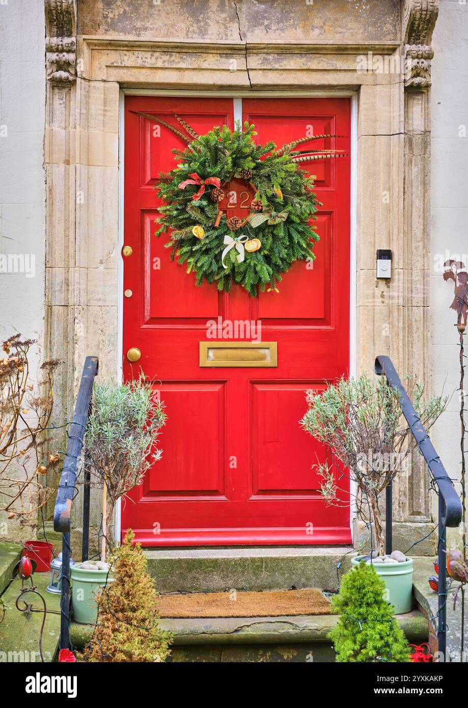 Couronne de l'Avent sur une porte rouge au 22 Minster court, Lincoln, Angleterre. Banque D'Images