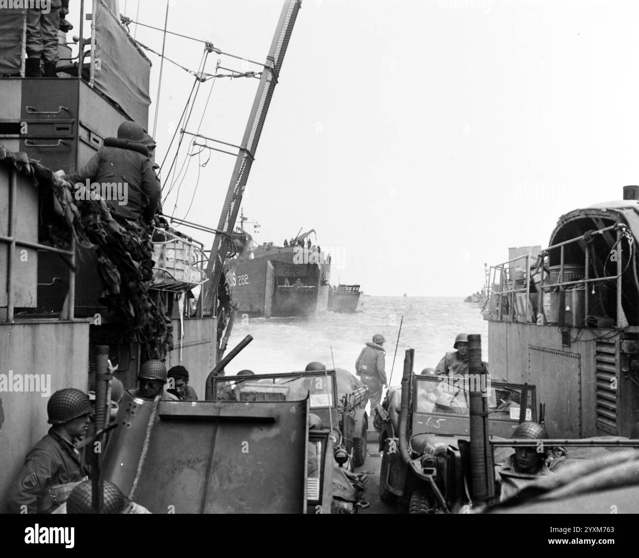 LCT transportant des jeeps jusqu’à la plage de Normandie, après les avoir déchargées de l’USS LST-282, en arrière-plan, 15 juin 1944. Notez les tubes de reniflard du moteur sur les Jeeps, pour traverser l'eau entre le LCT et le rivage - combat photo Unit Eleven (CPU-11) Banque D'Images