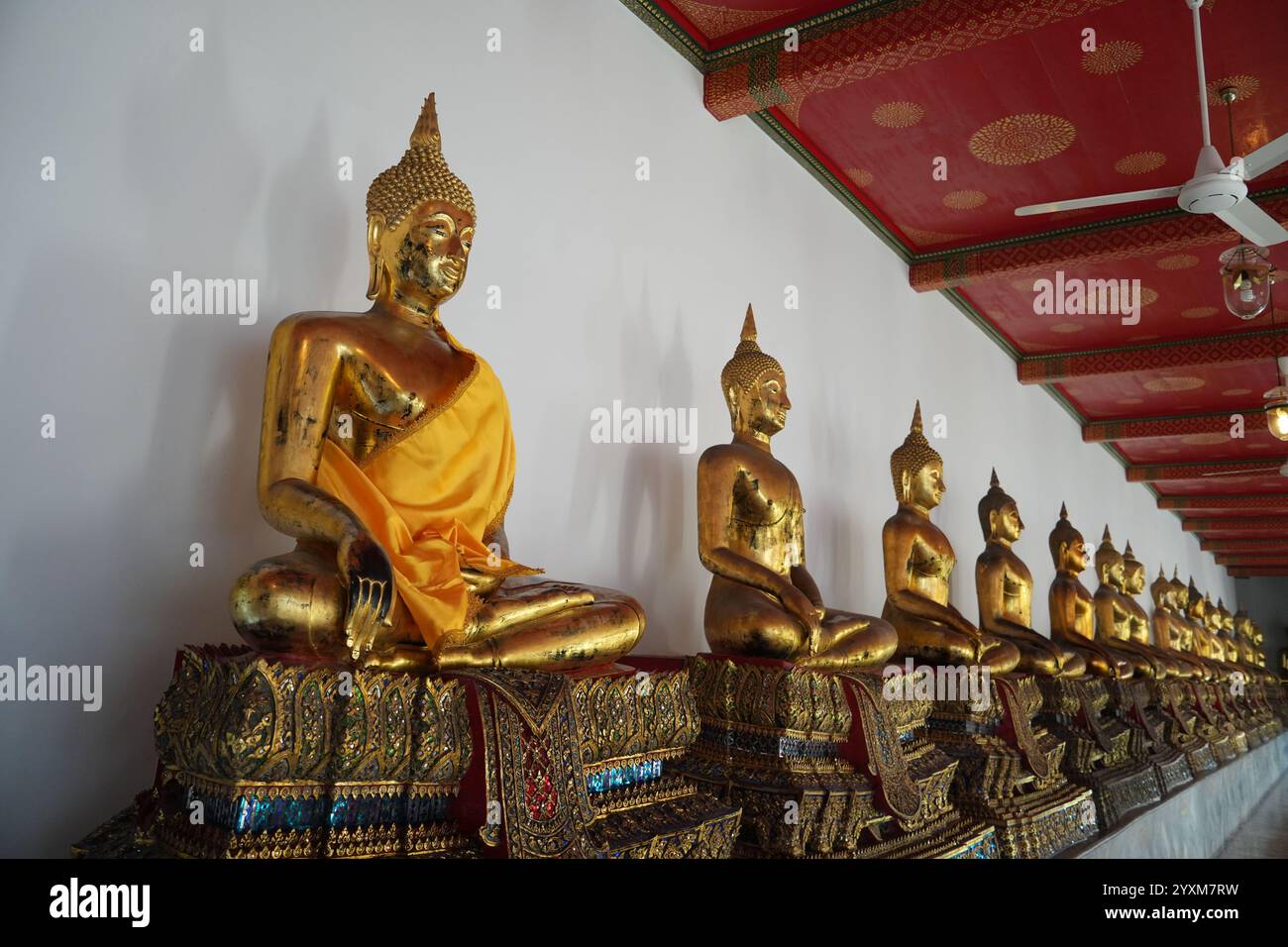 Bangkok, Thaïlande - 29 novembre 2024 : une rangée de statues de Bouddha dorées bordant un mur au temple Wat Pho à Bangkok. belles statues rayonnantes dorées Banque D'Images