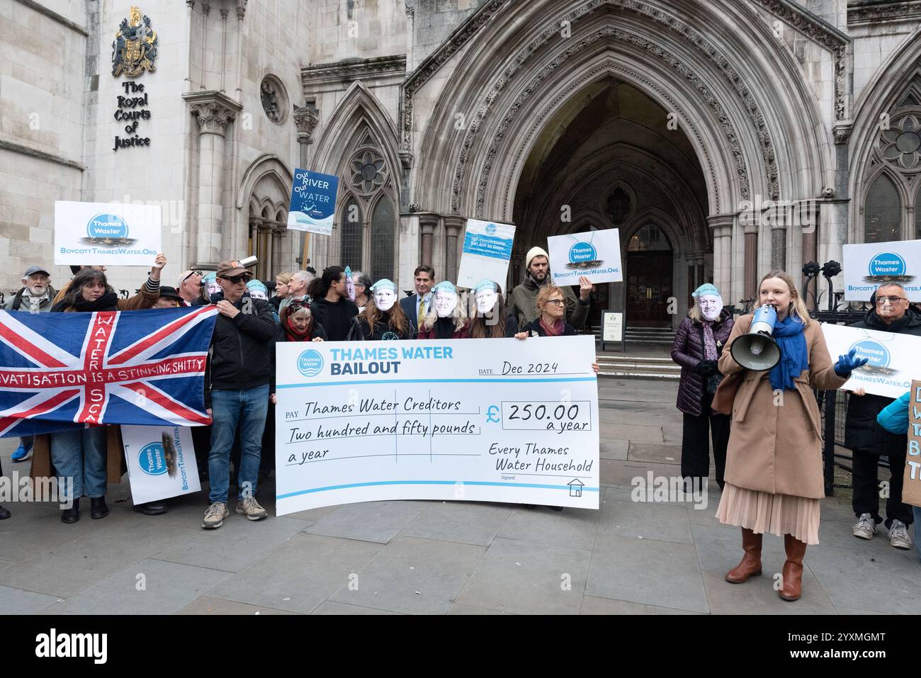 Londres, Royaume-Uni. 17 décembre 2024. Des activistes de We Own It détiennent un chèque géant lors d'un rassemblement devant les cours royales de justice appelant Steve Reed, secrétaire d'État à l'environnement, à l'alimentation et aux Affaires rurales, à bloquer le projet de renflouement financier de Thames Water, une entreprise privée. La société, la compagnie d'eau la plus lourdement endettée d'Angleterre et du pays de Galles, est au bord de la faillite. Les militants pensent que c'est une preuve supplémentaire que l'eau devrait être ramenée à la propriété publique. Crédit : Ron Fassbender/Alamy Live News Banque D'Images