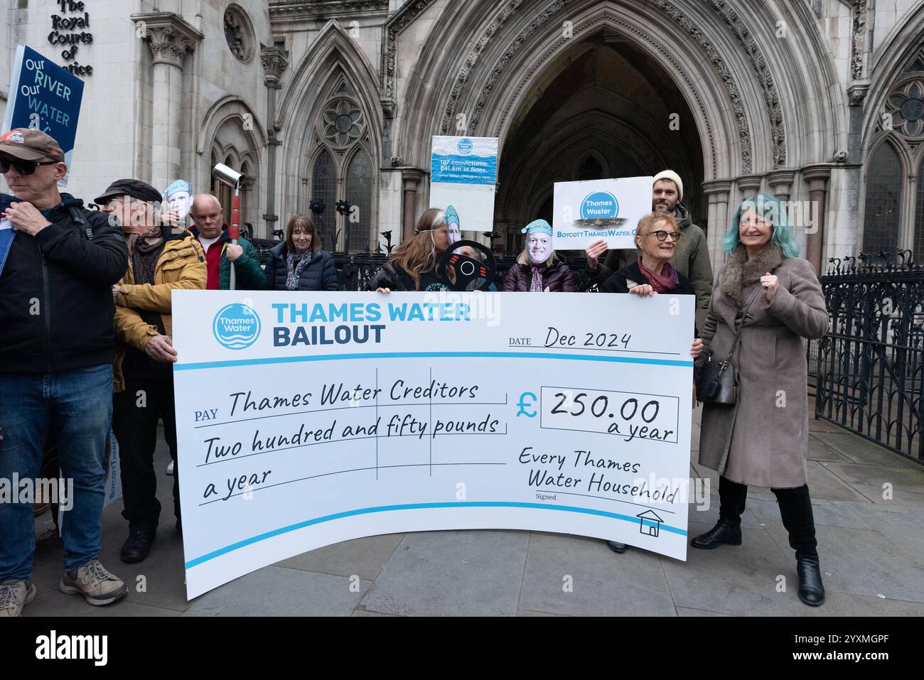 Londres, Royaume-Uni. 17 décembre 2024. Des activistes de We Own It détiennent un chèque géant lors d'un rassemblement devant les cours royales de justice appelant Steve Reed, secrétaire d'État à l'environnement, à l'alimentation et aux Affaires rurales, à bloquer le projet de renflouement financier de Thames Water, une entreprise privée. La société, la compagnie d'eau la plus lourdement endettée d'Angleterre et du pays de Galles, est au bord de la faillite. Les militants pensent que c'est une preuve supplémentaire que l'eau devrait être ramenée à la propriété publique. Crédit : Ron Fassbender/Alamy Live News Banque D'Images