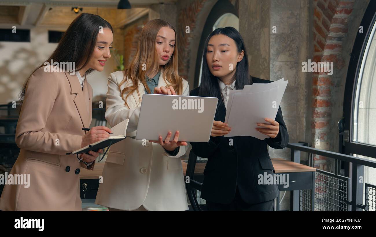 Groupe entreprise remue-méninges femmes d'affaires trois femmes multiraciales multiethniques diversité femmes d'affaires asiatiques filles caucasiennes dans des documents de bureau Banque D'Images