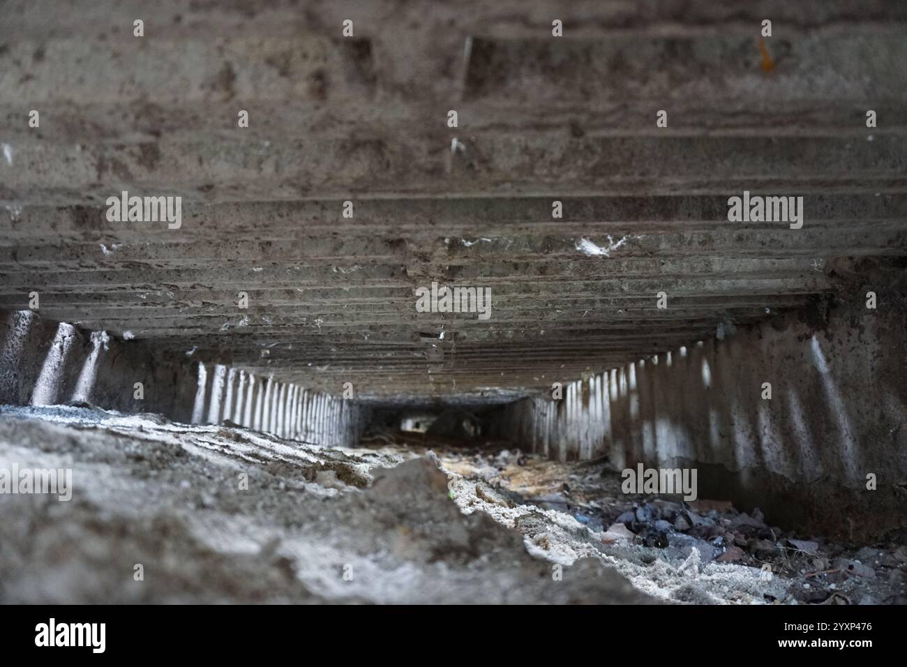 Un grand espace vide avec un sol en béton. L'espace est rempli de débris et de saleté, lui donnant un aspect sale et abandonné. Le vide du Banque D'Images