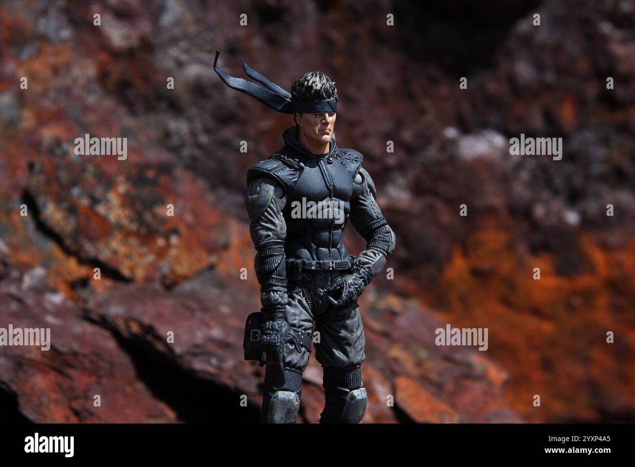 Metal Gear Solid action figure scène extérieure fond en métal rouillé vue de trois quarts Banque D'Images