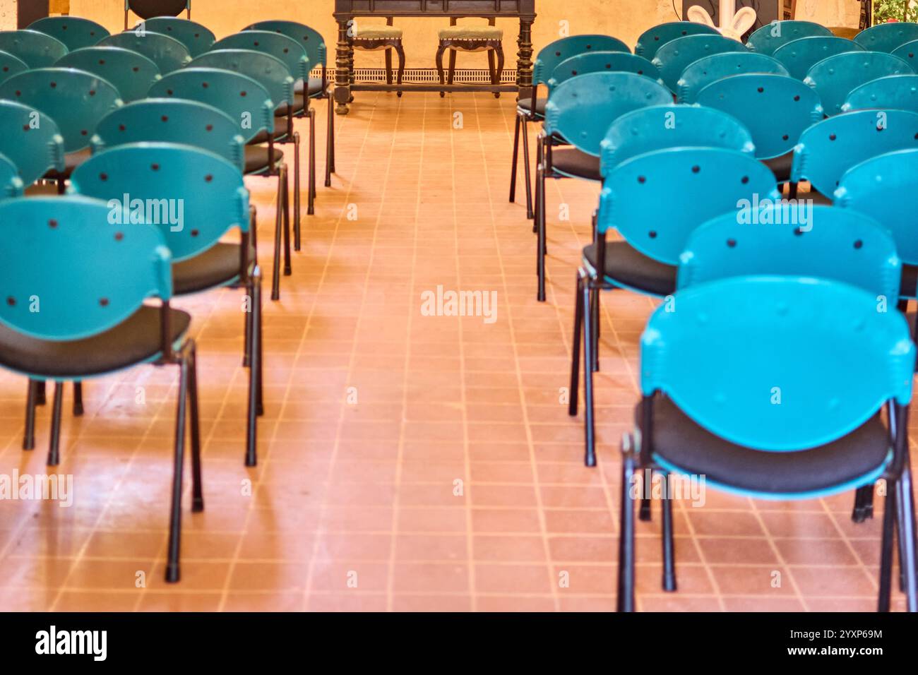 Chaises bleues disposées en rangées dans une salle de conférence vacante. Concept : idéal pour les réunions d'affaires, les présentations ou les sessions de formation, en mettant l'accent sur un cle Banque D'Images