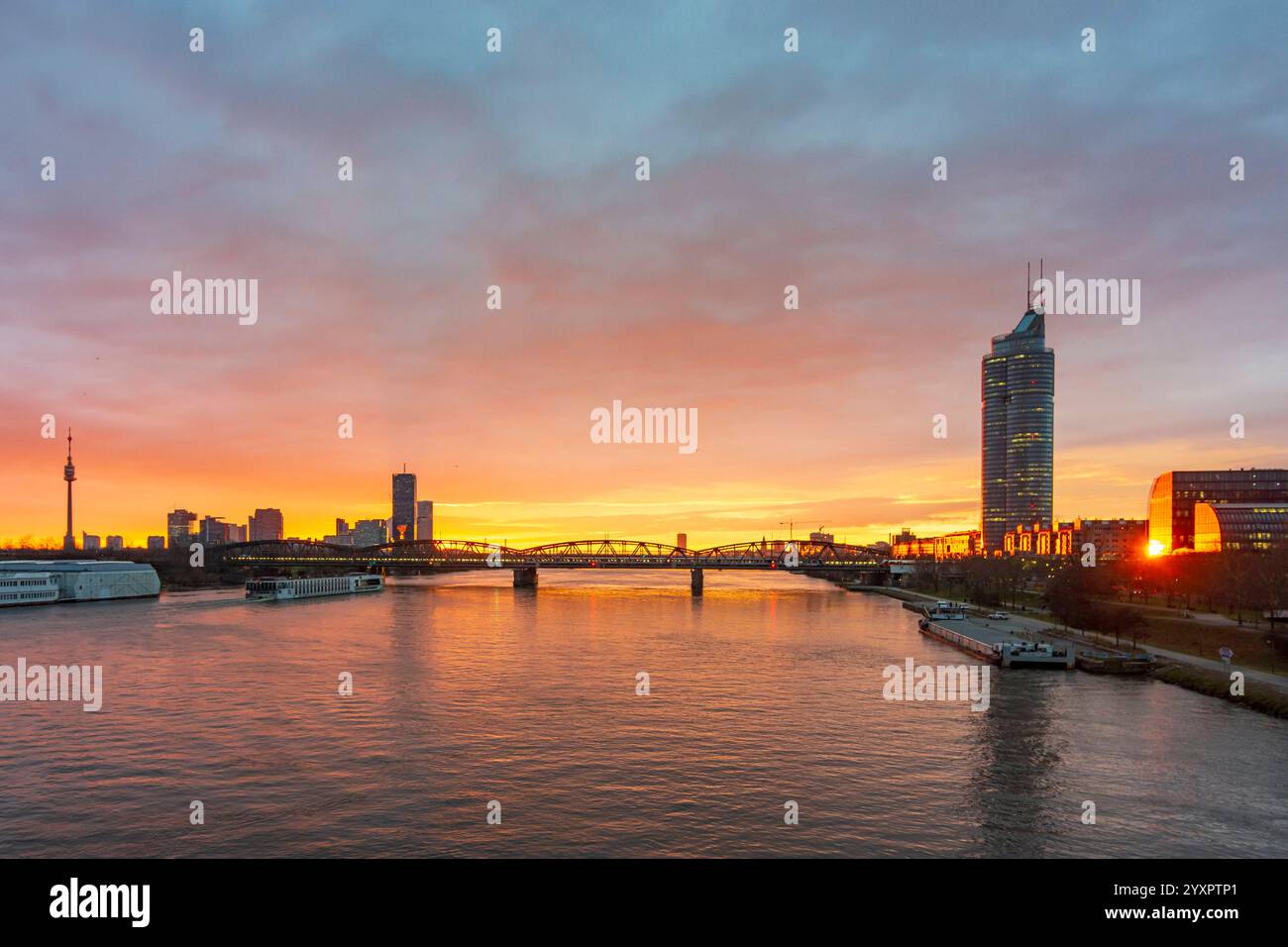 Lever de soleil ardent sur la rivière Donau Danube, bateau de croisière, pont Nordbahnbrücke, gratte-ciel à Donaucity avec DC Tower 1, Millennium Tower Right Vienna 20. BR Banque D'Images