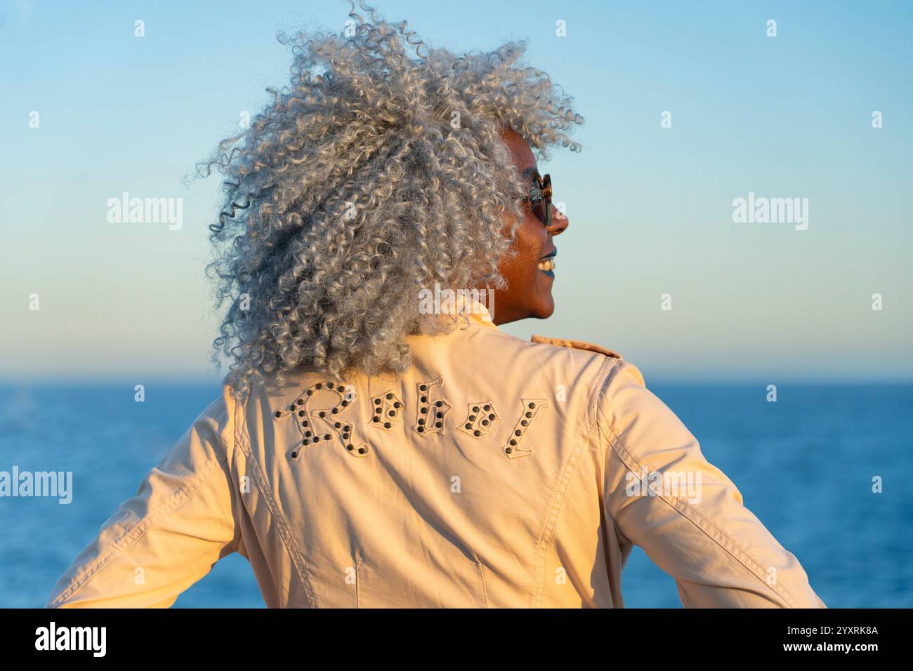 Gros plan arrière d'une dame afro-américaine portant une veste avec le mot rebelle. Concept : pro-âge, rebelle Banque D'Images