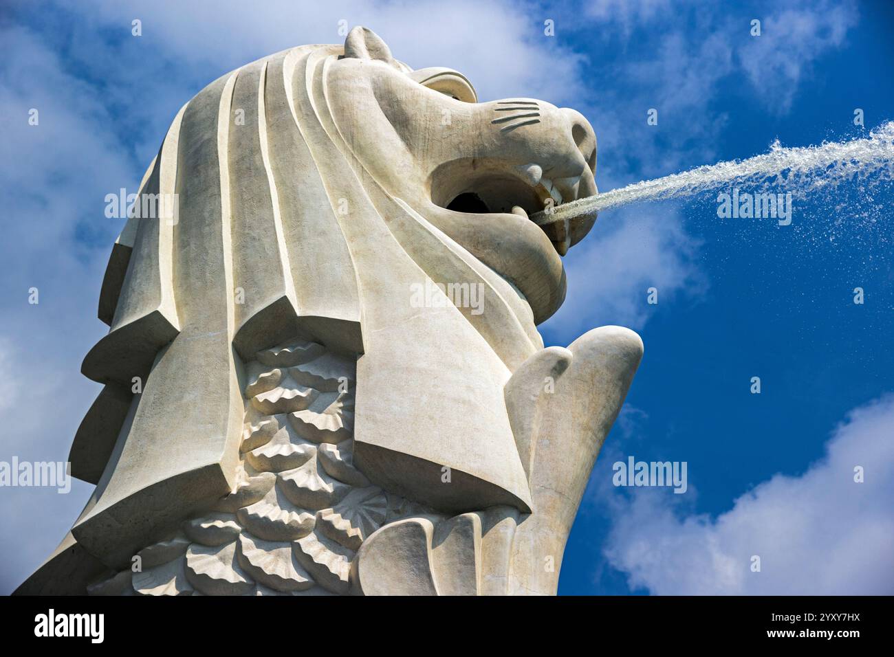 Statue de Merlion à Merlion Park à Singapour jaillissant de l'eau contre un ciel bleu clair avec des nuages moelleux. Photo : David Rowland / One-Image.com Banque D'Images
