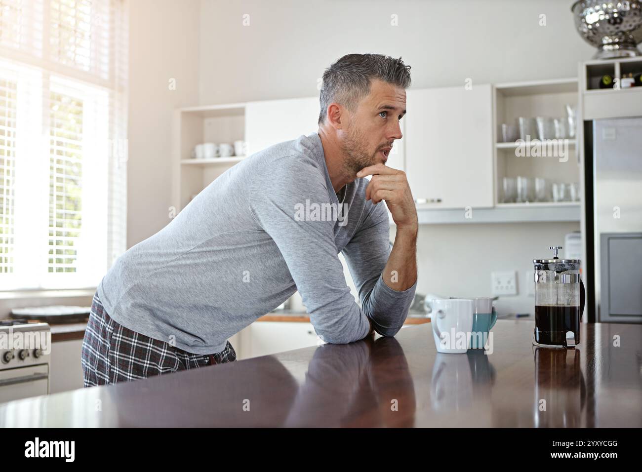Matin, la pensée et l'homme dans la cuisine avec du café pour commencer la journée avec boisson de caféine, boisson chaude et cappuccino. Réfléchi, maison et personne avec Banque D'Images
