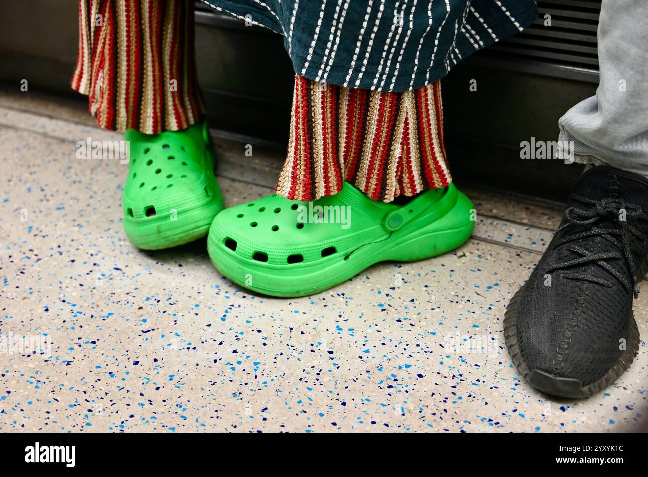 une femme portant un crock vert vif dans un train de train de train à tube à londres angleterre royaume-uni Banque D'Images