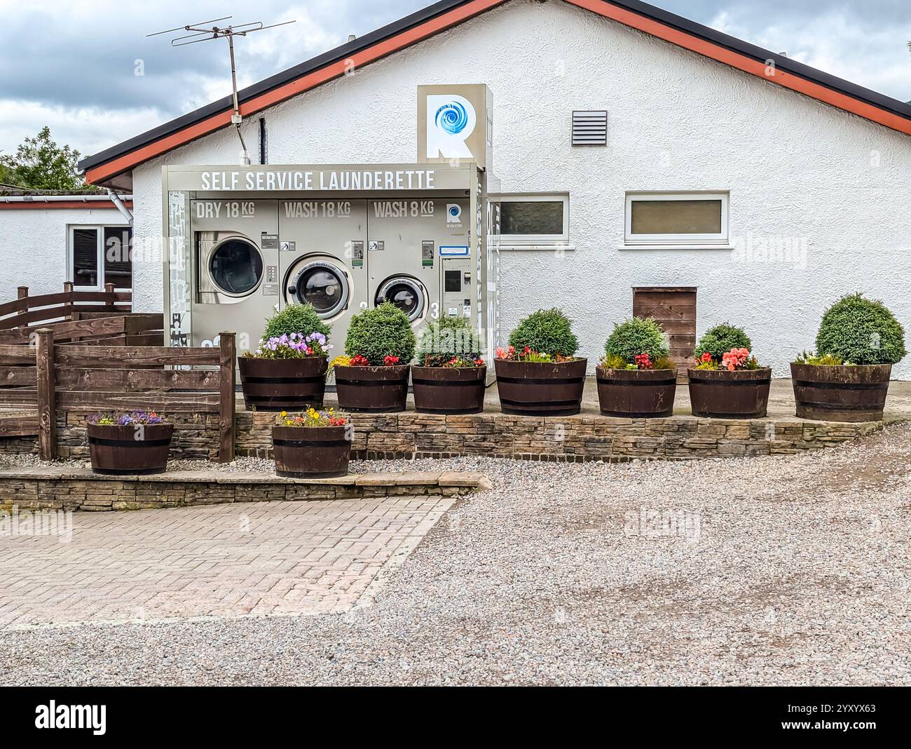 Laverie en libre-service Revolution avec deux machines à laver et un sèche-linge au Green Welly Stop, Tyndrum, Écosse, Royaume-Uni Banque D'Images