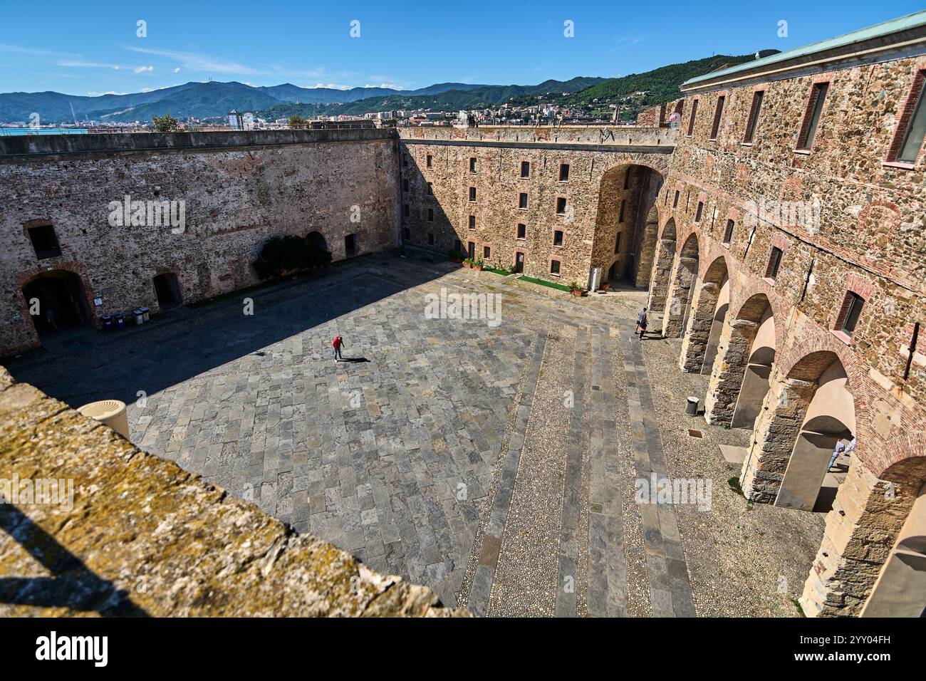 Savone, Italie - 18 décembre 2024 : vue panoramique sur la forteresse de Priamar, mêlant architecture ancienne et paysage urbain moderne sous un ciel bleu clair. Highl Banque D'Images