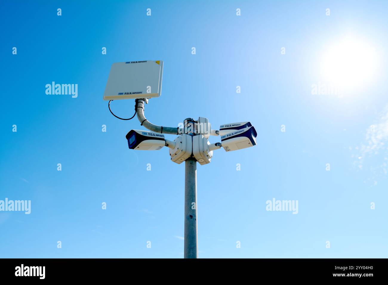 Savona, Italie - 18 décembre 2024 : caméras de sécurité modernes montées sur un poteau contre un ciel bleu vif. Représentation idéale de la surveillance, de la sécurité, Banque D'Images