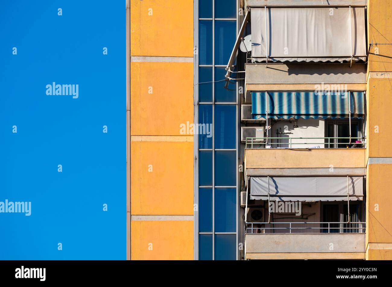 Détail d'un immeuble jaune avec balcons à Tirana, Albanie, 7 décembre 2024 Banque D'Images