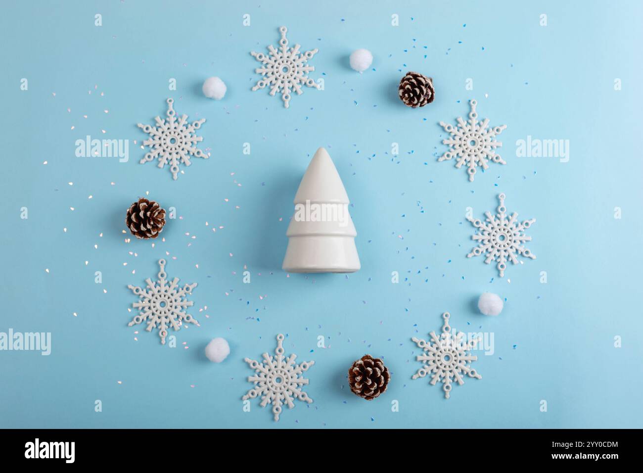 Figurine blanche d'arbre de Noël et flocons de neige sur fond bleu. Vue de dessus, pose à plat, espace de copie. Banque D'Images