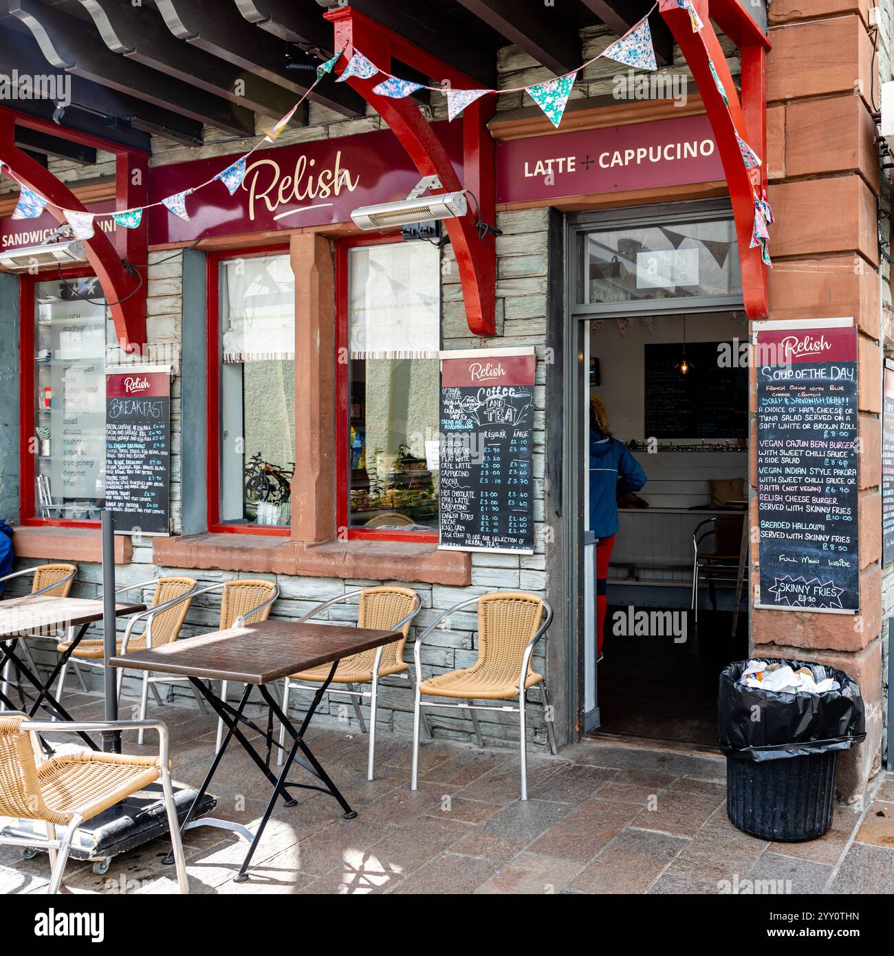 Vue extérieure du café Relish, Keswick, avec des tables et des chaises sur le trottoir, et des panneaux de menu sur les murs Banque D'Images