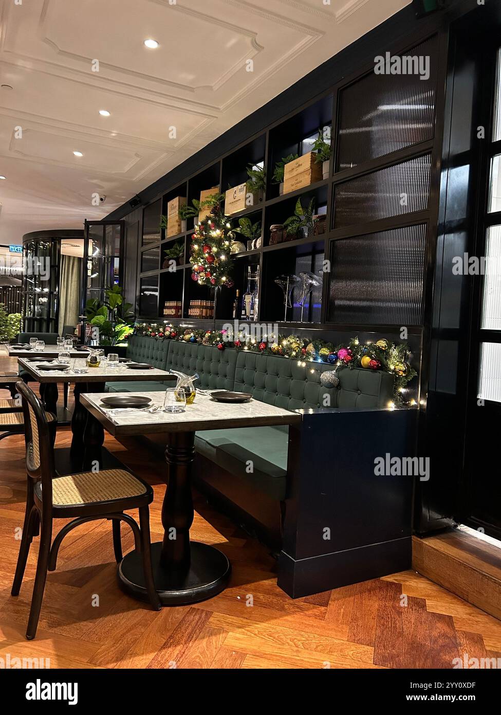 Confortable restaurant italien joliment décoré pour la saison de Noël, avec un éclairage chaleureux de fête, parfait pour les déjeuners d'affaires ou les rendez-vous romantiques - Image de stock capturée avec un smartphone