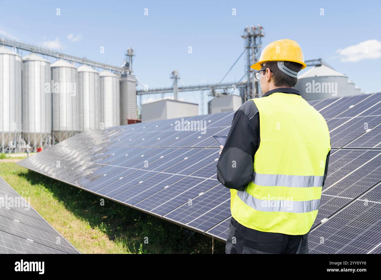Ingénieur avec tablette numérique sur un fond de ferme moderne utilisant des énergies renouvelables .. Banque D'Images