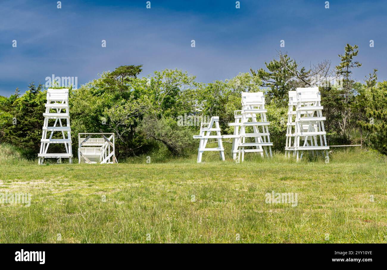 groupe de gardes-nageurs blancs stockés dans un champ vert près de la plage Banque D'Images
