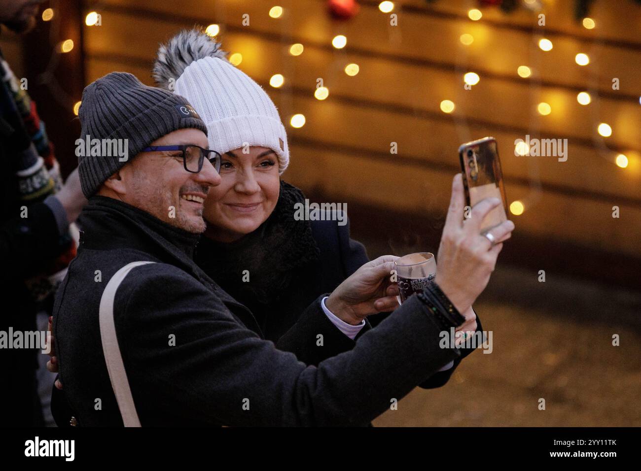 Les visiteurs prennent des selfies aux marchés de Noël de Poznan (Betlejem Pozna?skie) sur la place de la liberté dans le centre de Poznan. Pozna ? Marchés de Noël (Betlejem Pozna?skie) – une foire annuelle de Noël au cœur de Pozna?. L'atmosphère unique du marché de Noël est créée par des décorations et des illuminations festives, un sapin de Noël, une grande roue, un carrousel vénitien, et une scène de Noël présentant un répertoire artistique local, des événements thématiques le week-end et des ateliers pour les enfants. Banque D'Images