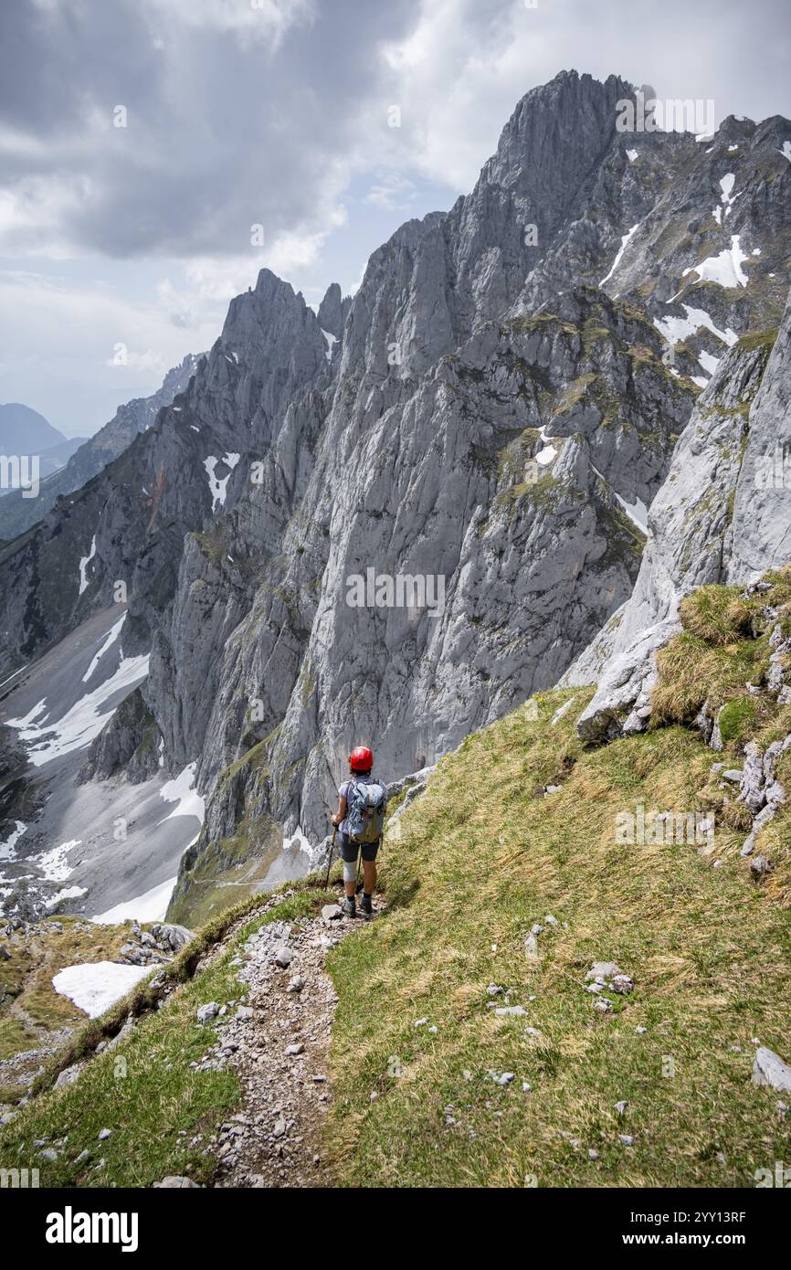 Alpiniste avec casque sur un sentier de randonnée, Wilder Kaiser, montagnes Kaiser, Tyrol, Autriche, Europe Banque D'Images