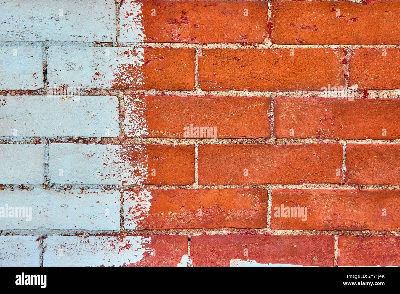 Contraste des briques blanches et rouges pelées en gros plan Urban texture Banque D'Images