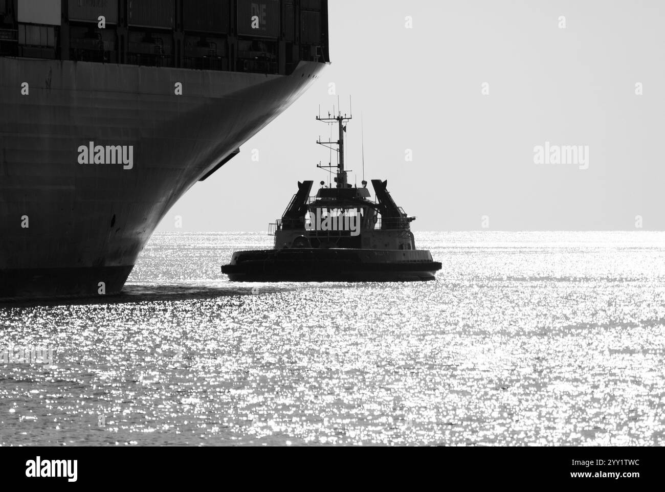 Remorqueur Willy T aidant un porte-conteneurs. Banque D'Images