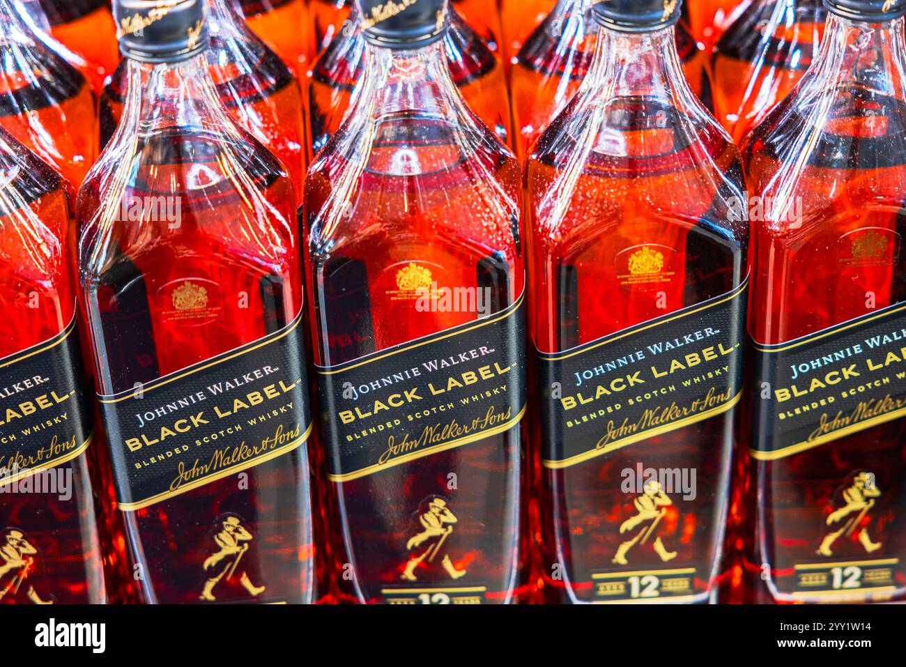 Vue rapprochée des bouteilles de whisky scotch mélangé Johnnie Walker Black Label avec des reflets rouges sur l'étagère du magasin. Suède. Stockholm. Banque D'Images