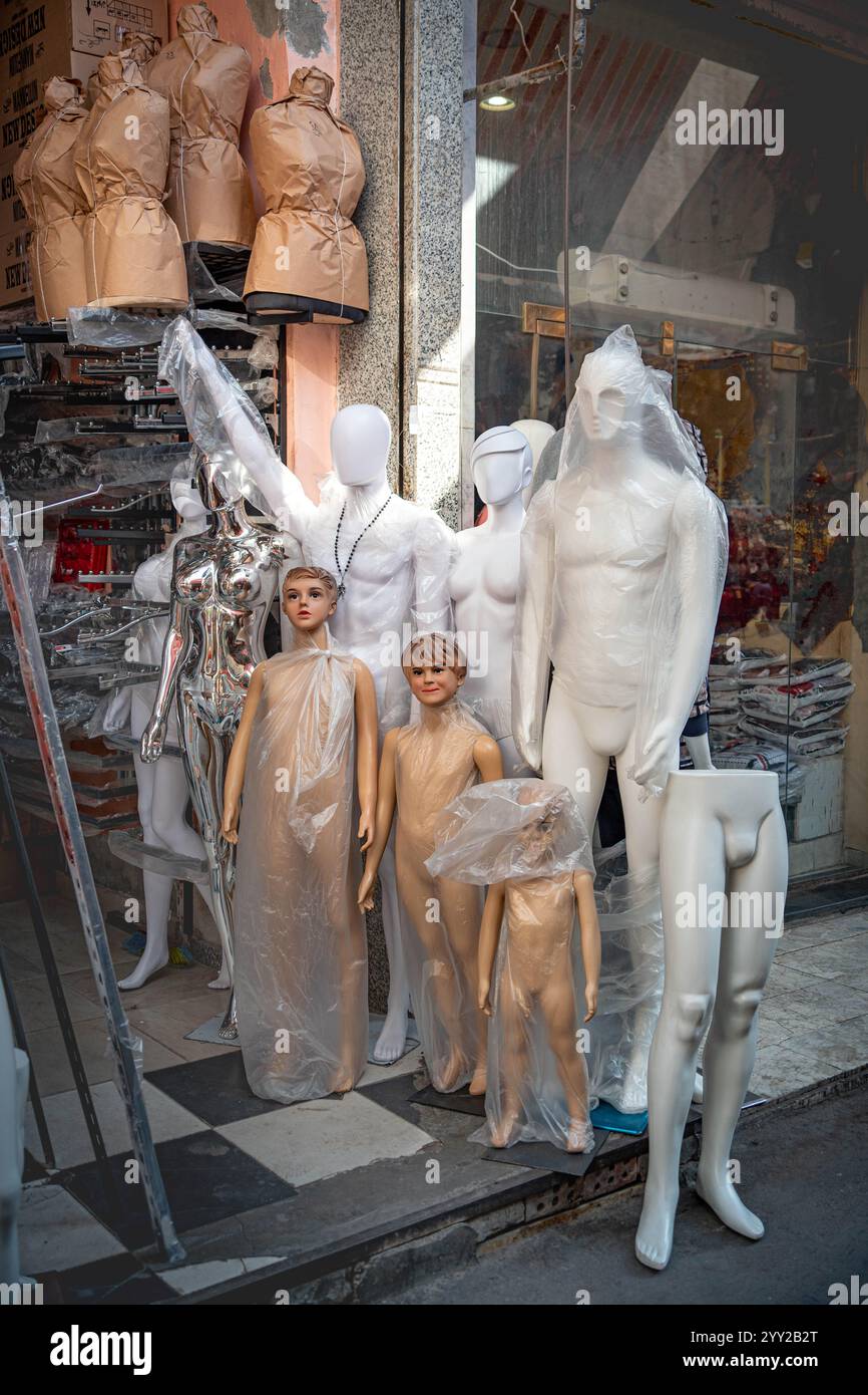 Une exposition de mannequins enveloppés dans du plastique à l'extérieur d'un magasin à Alexandrie, en Égypte, présente diverses formes, des adultes aux enfants pour les expositions de vêtements Banque D'Images