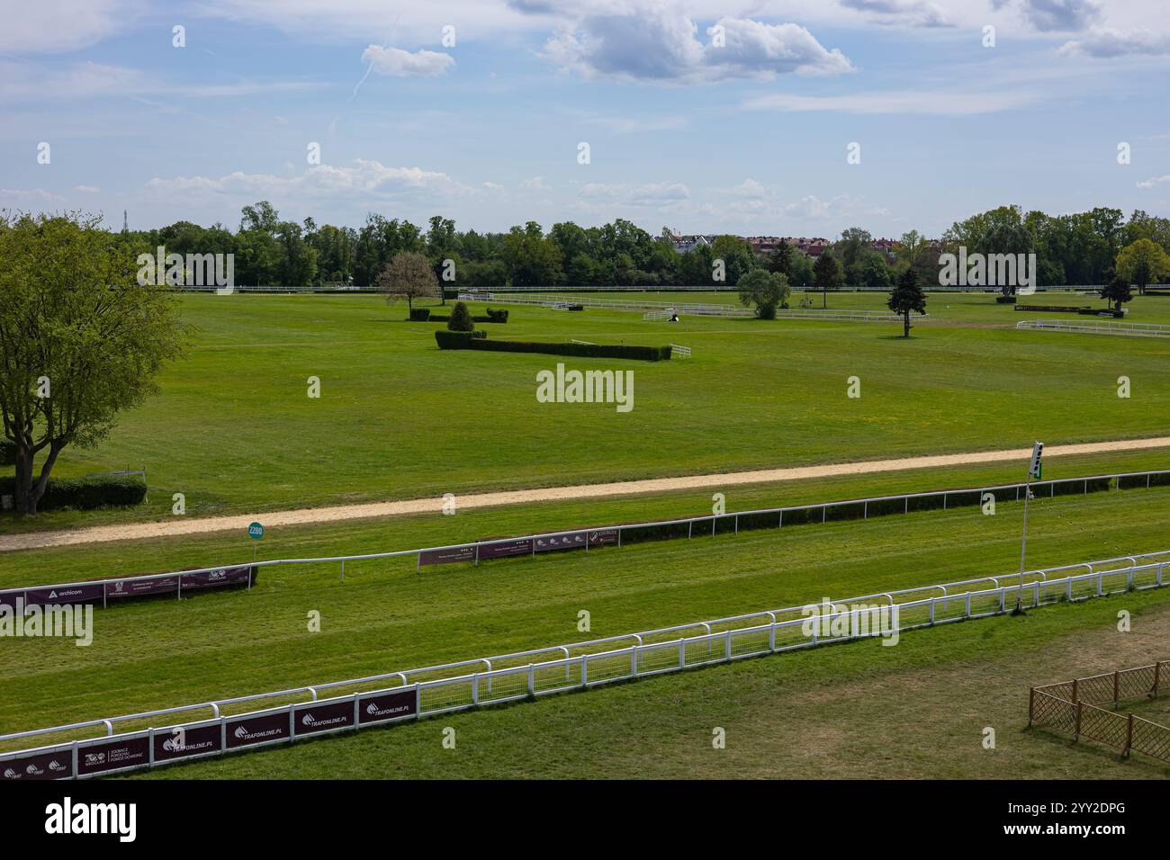 Wroclaw, Pologne- Maj 3, 2024 : vue panoramique d'une piste de course hippique verte par une journée ensoleillée à l'hippodrome de la ville historique avec de l'herbe verte, des clôtures blanches Banque D'Images