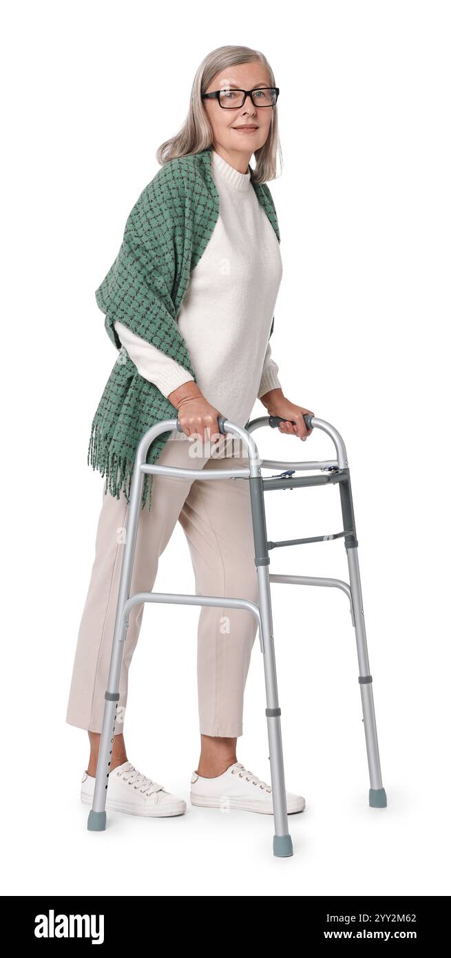 Femme senior utilisant le cadre de marche sur fond blanc Banque D'Images