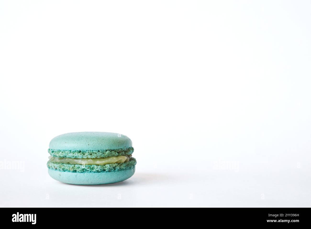Un macaron français vert, aigue-marine sur fond gris, gâteau à saveur de menthe. Dessert maison, macaron. Copier l'espace pour le texte Banque D'Images