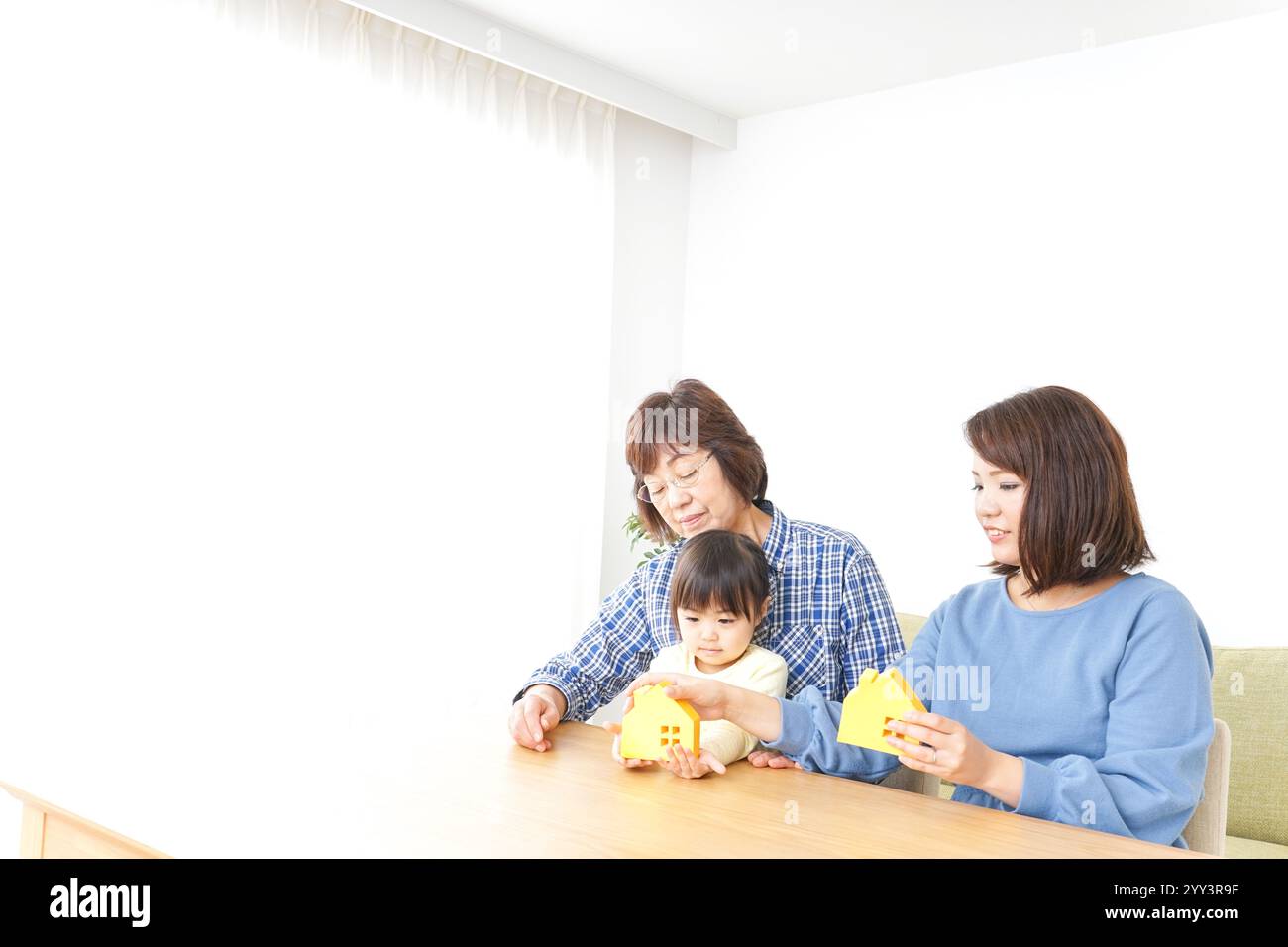 Trois générations trouvant une image de maison Banque D'Images