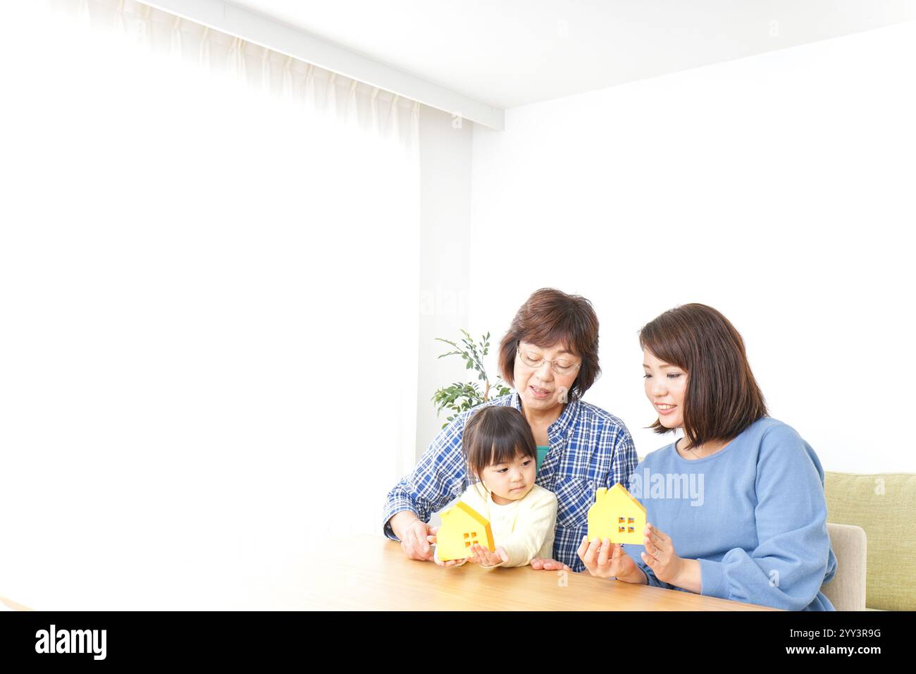 Trois générations trouvant une image de maison Banque D'Images