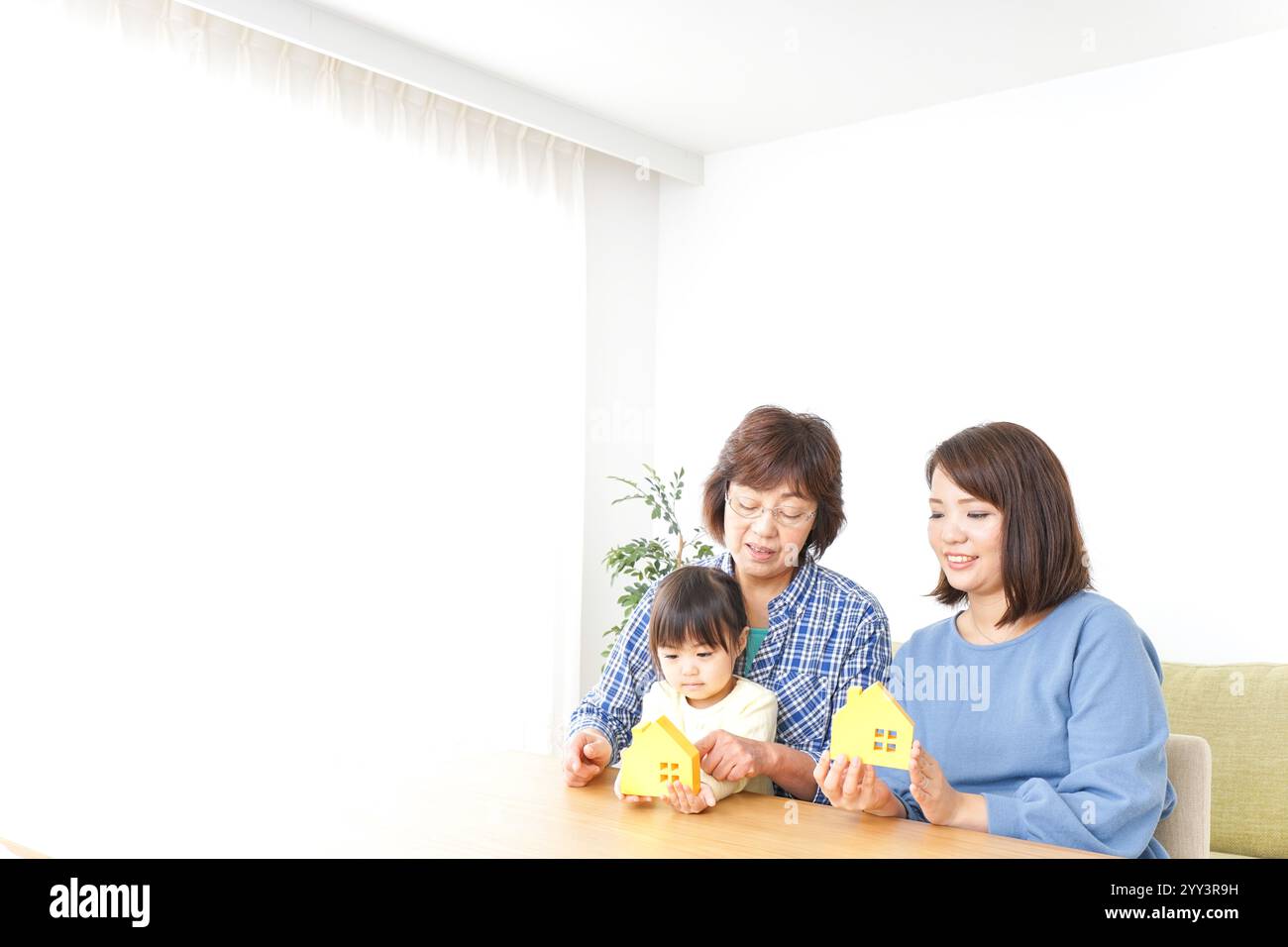 Trois générations trouvant une image de maison Banque D'Images